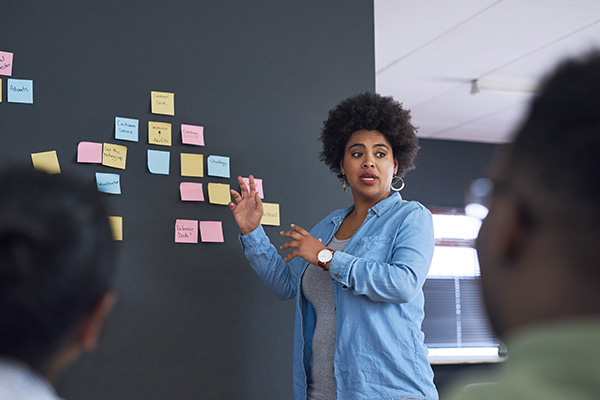 HR manager discussing plans on a blackboard.