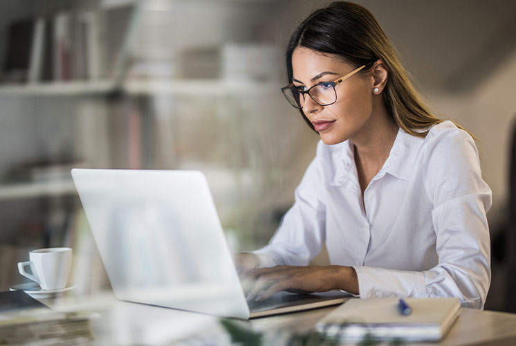 Mujer leyendo atentamente en su computadora portátil