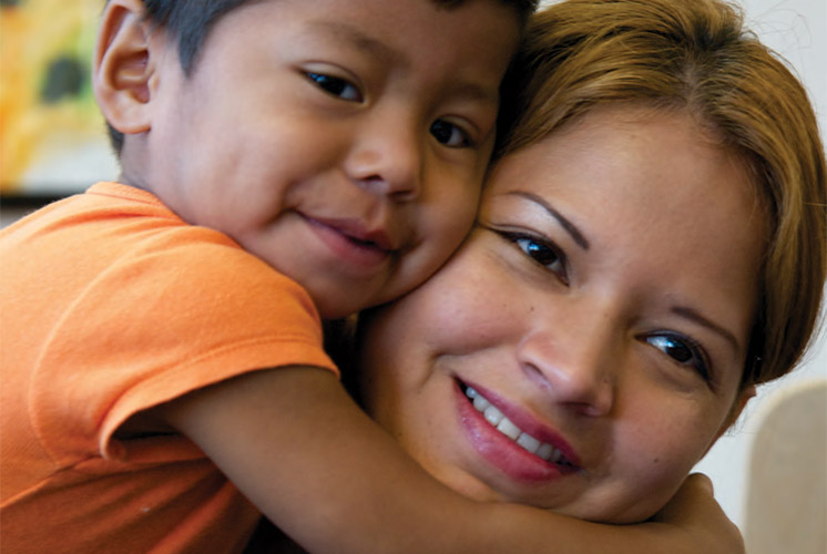 Un niño sonriente abrazando a su madre