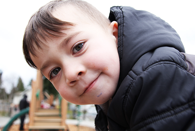 Un niño mirando directamente a la cámara, sonriendo