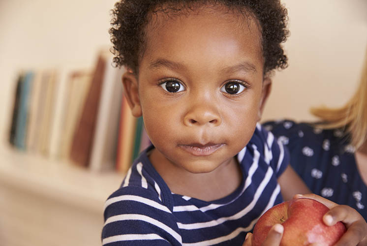 a boy is holding an apple