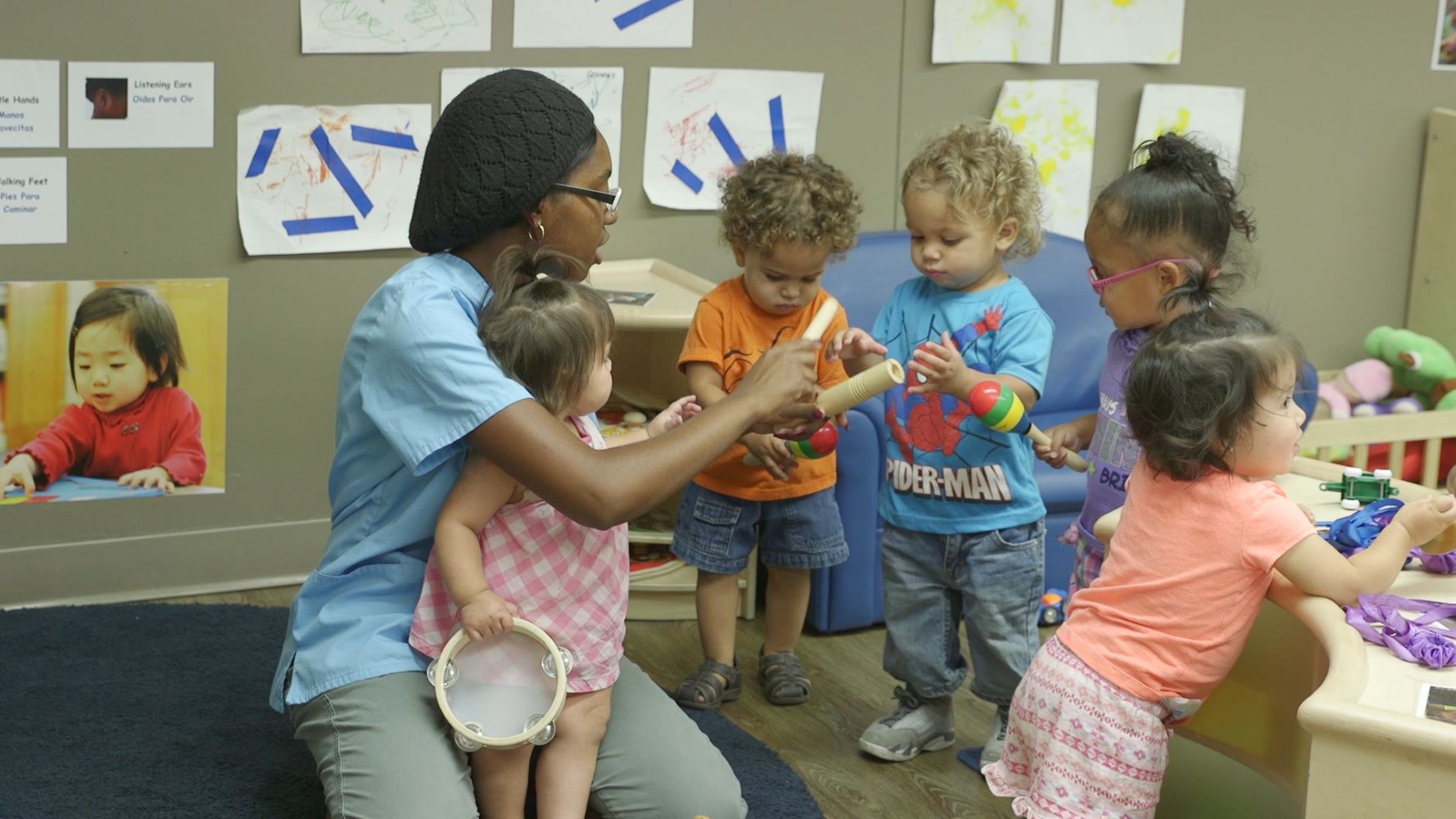 Teacher overseeing children with musical instruments.