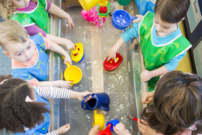 Children playing with boats in the water