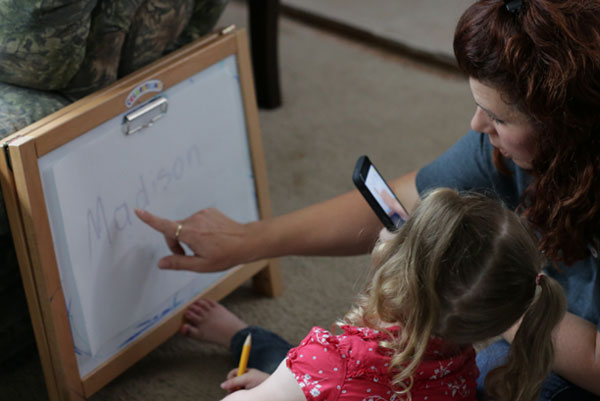 maestra con niña aprendiendo su nombre