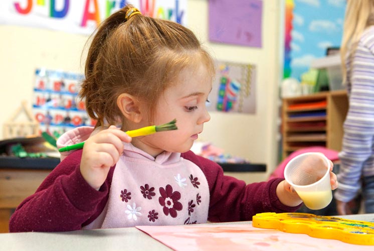 Niña jugando con materiales de arte