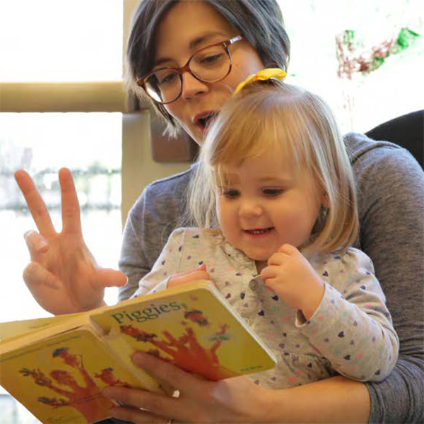 Maestra leyéndole un libro a una niña