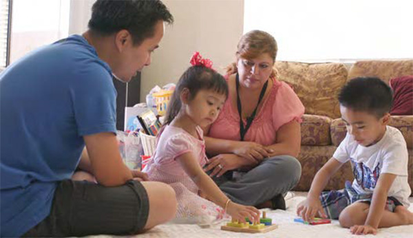 Padre y sus hijos con una visitadora del hogar