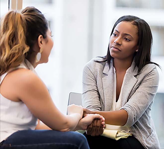 Woman listening to another with a look of concern