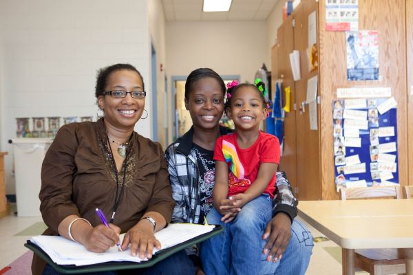 A mother and daughter with another woman taking notes.