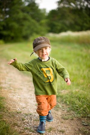 Young boy running on a dirt path.