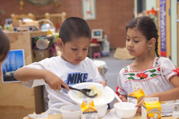 A boy and girl serving themselves food.