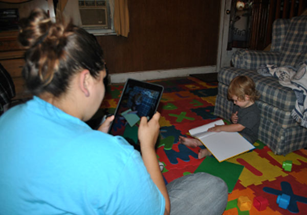 Home visitor recording a child reading