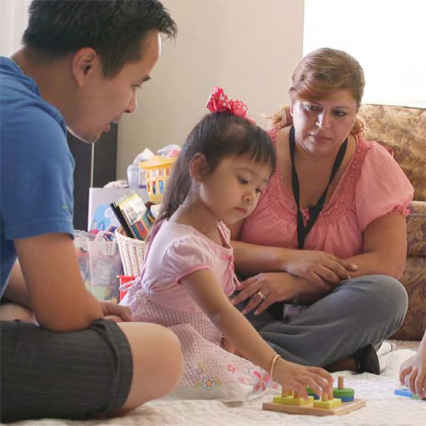 Padre con su hija y una visitadora del hogar