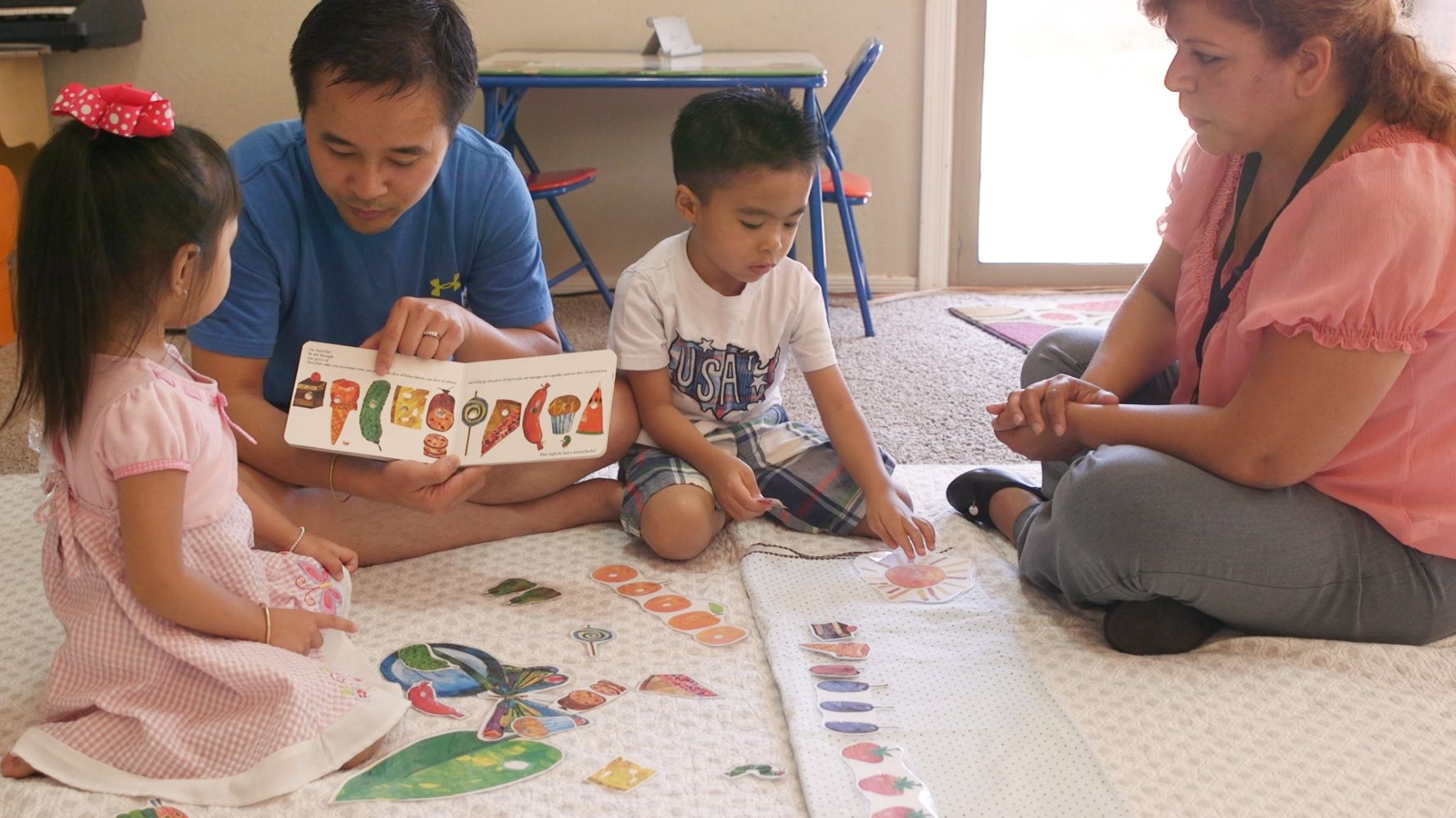 Parents reading a book to their children.