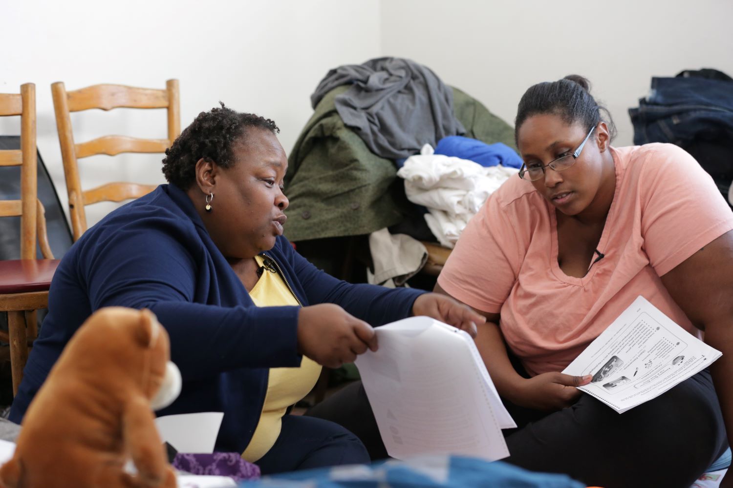 Two women looking at paperwork.