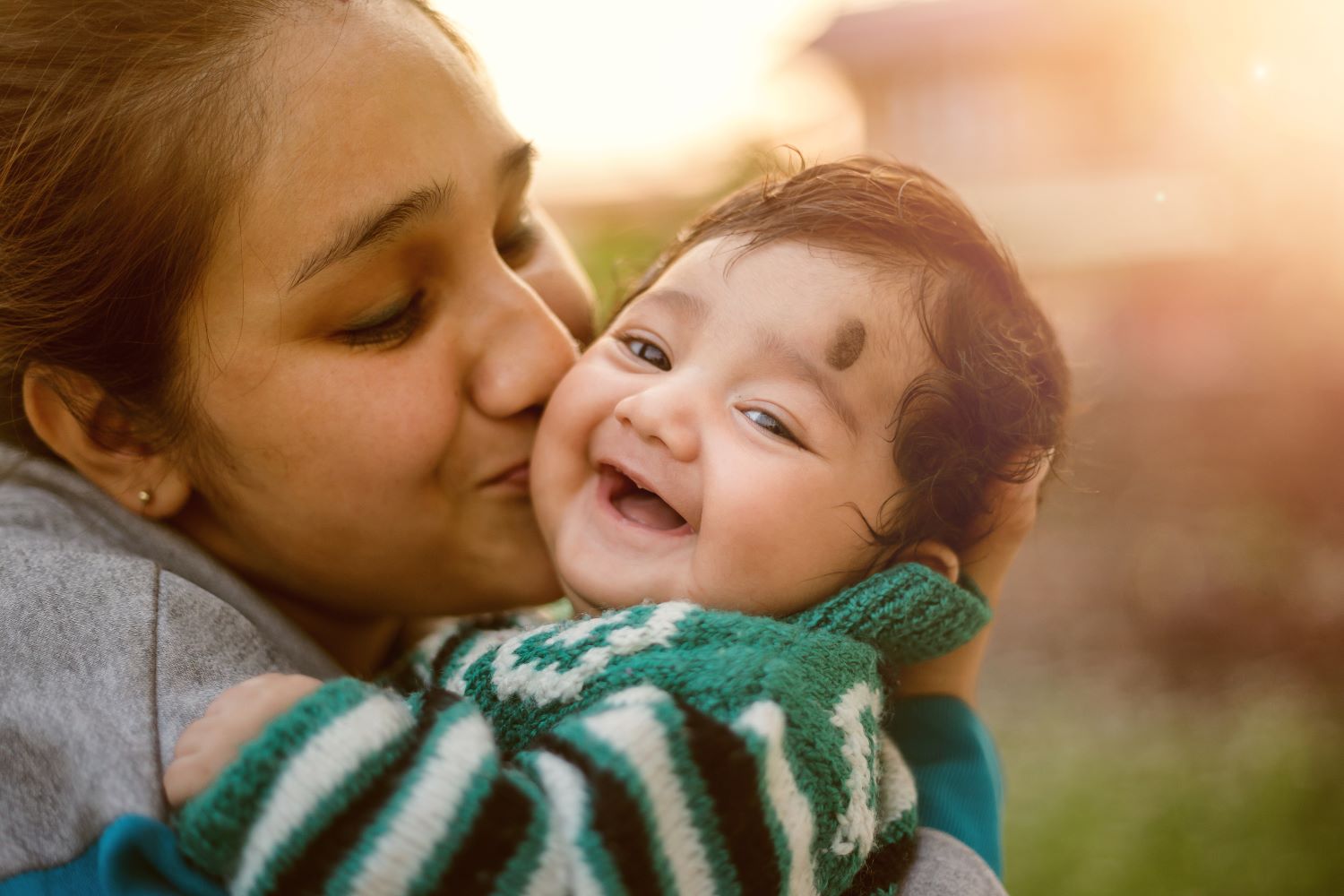 Mother kissing her child on the cheek.