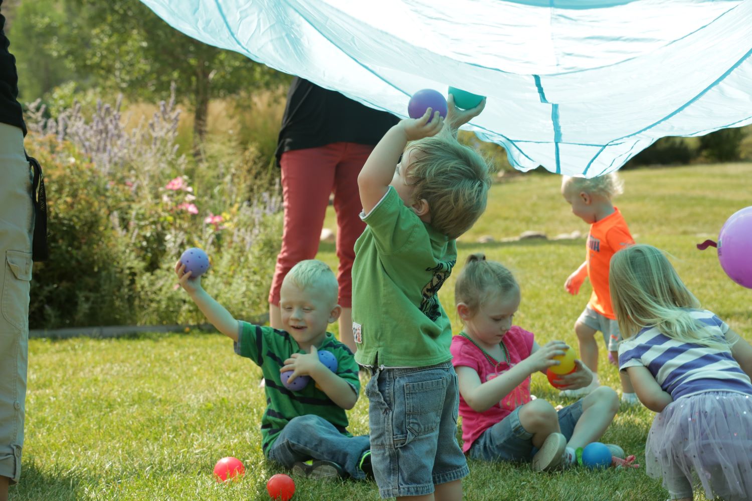 Children playing outdoors under a canopy.