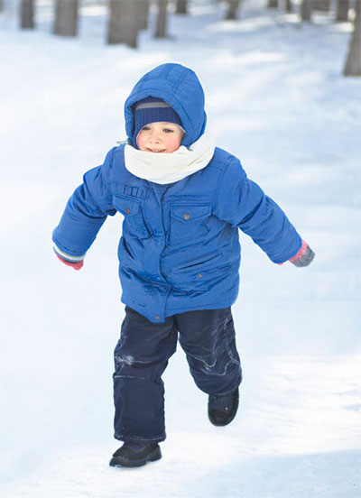 Little boy running in the snow