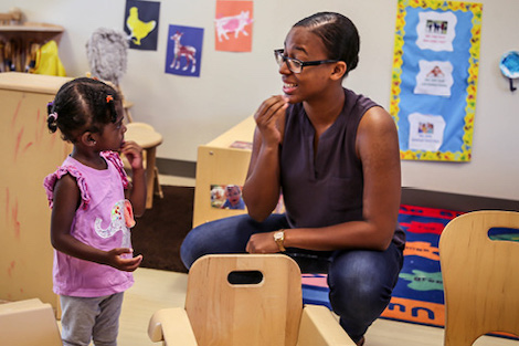 Little girl communicates with adult in classroom