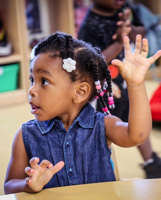 Little girl raising her hand