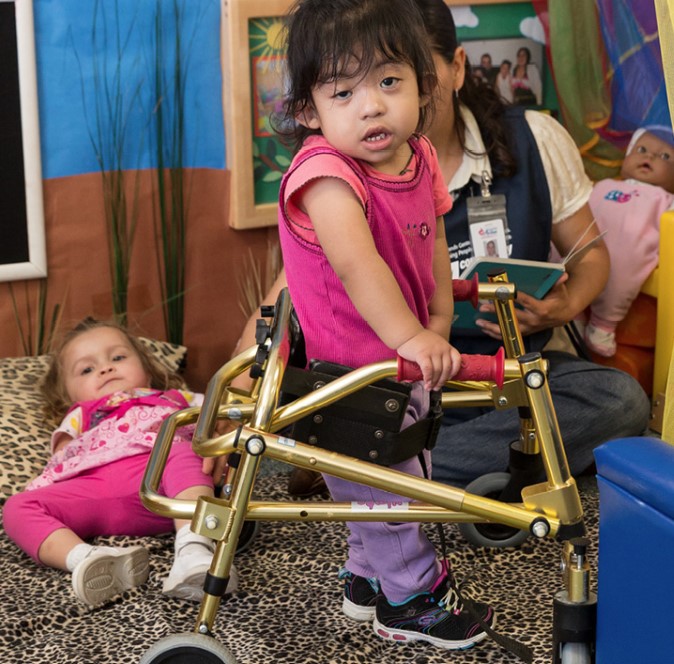 Little girl using walking support