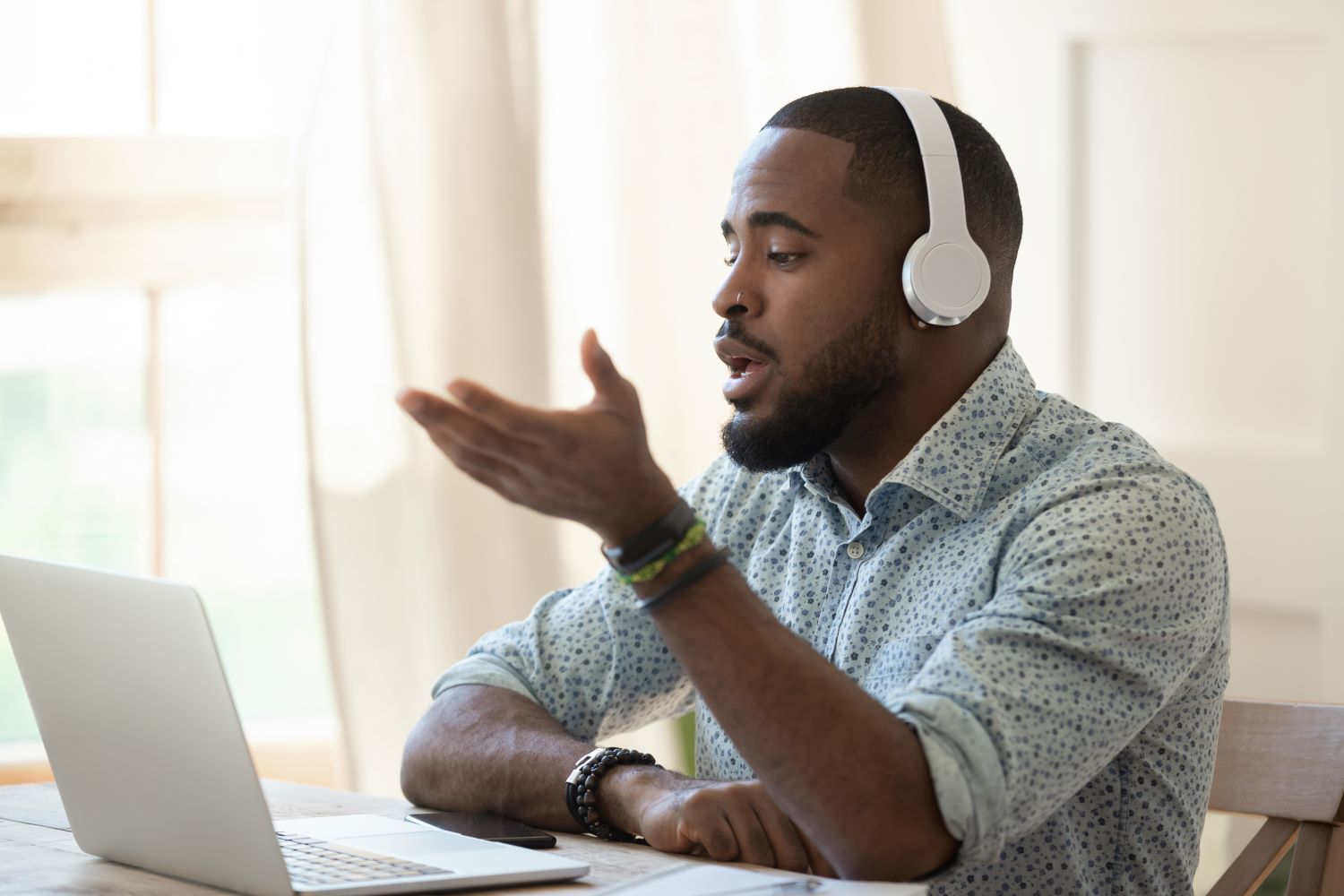 Hombre usando un portátil y con auriculares en un video-chat