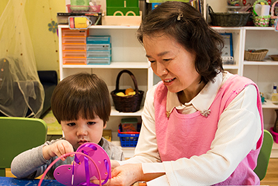 Teacher helping a toddler student with an activity