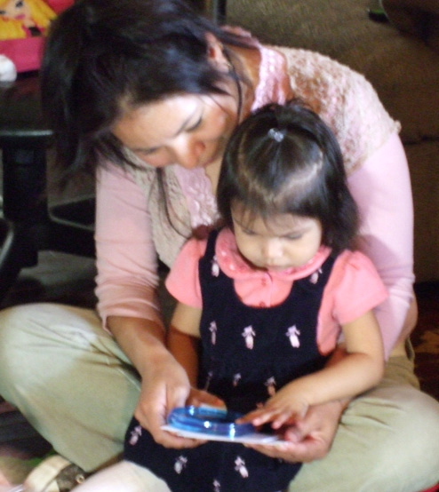 Mom holding daughter while she plays