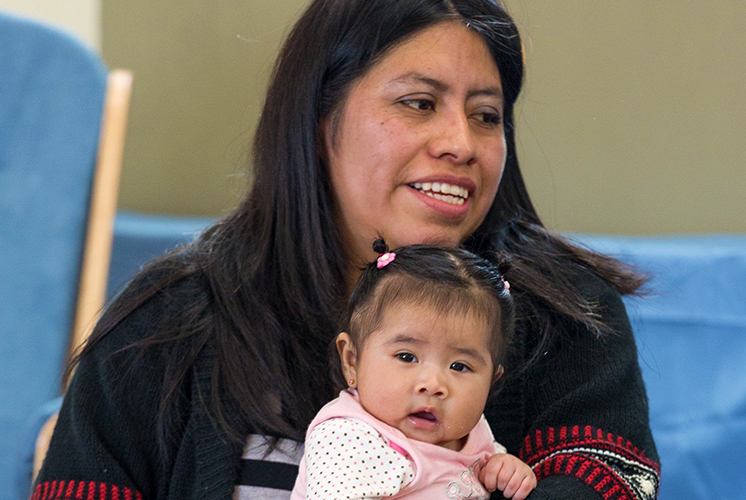 Mamá sosteniendo a una niña en su regazo