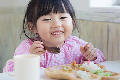 Smiling young girl enjoying a healthy meal.