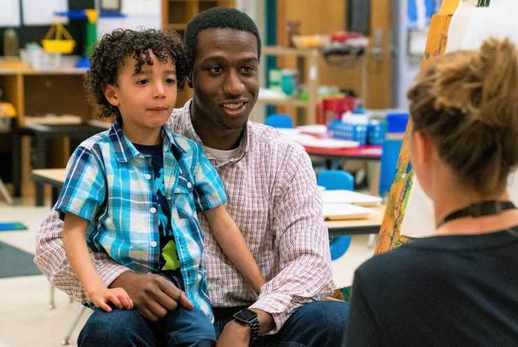 Parent and son talking to teacher