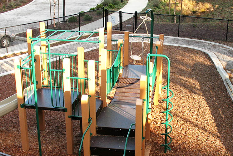 play equipment surrounded by walkway and fence