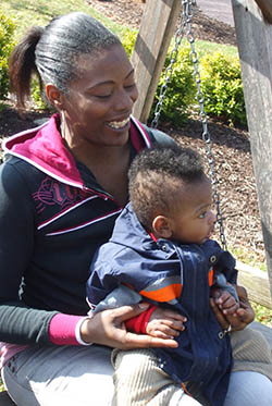 a woman on a porch swings holds a baby in her lap