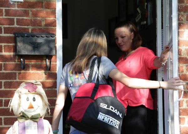 Madre abriéndole la puerta a una visitadora del hogar