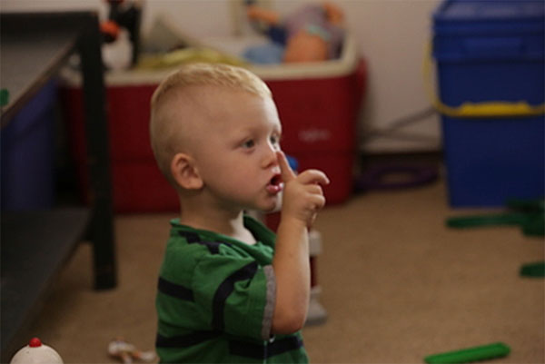 Niño pequeño sosteniendo un dedo para mandar a callar