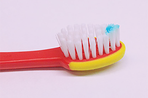 Use a smear of fluoride toothpaste