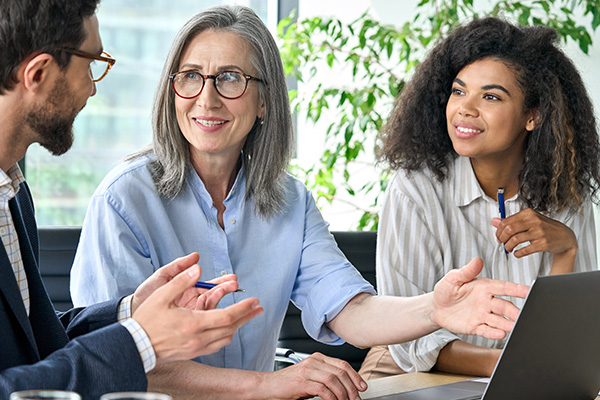 Varios empleados se reunien en una mesa.