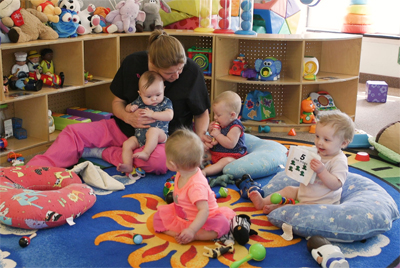 Teacher plays with children on the floor