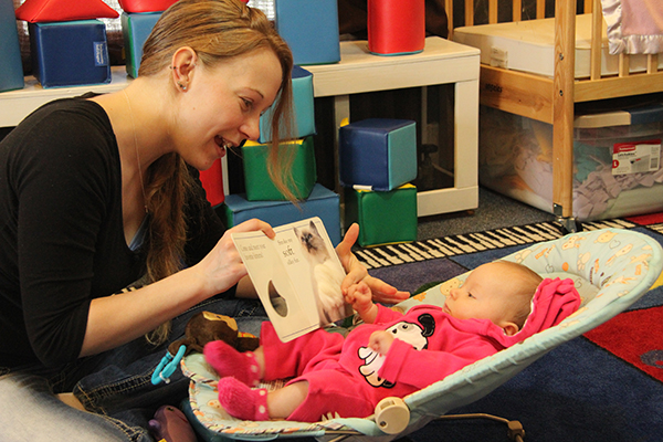 Teacher reading book to infant