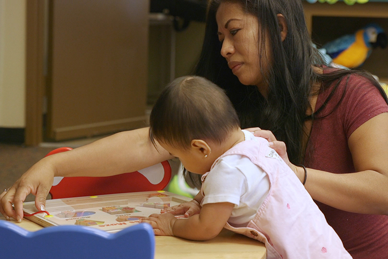 Teacher and toddler doing learning activity.