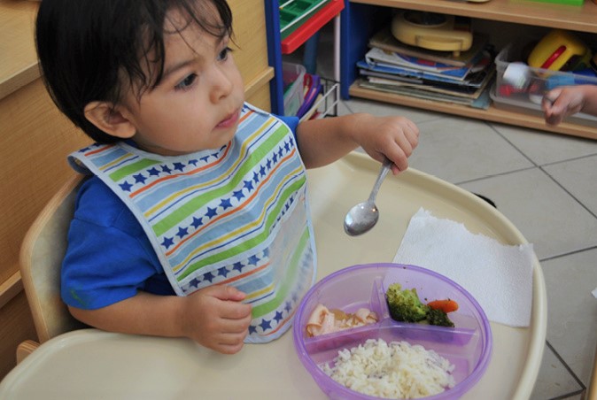 Toddler eating with spoon