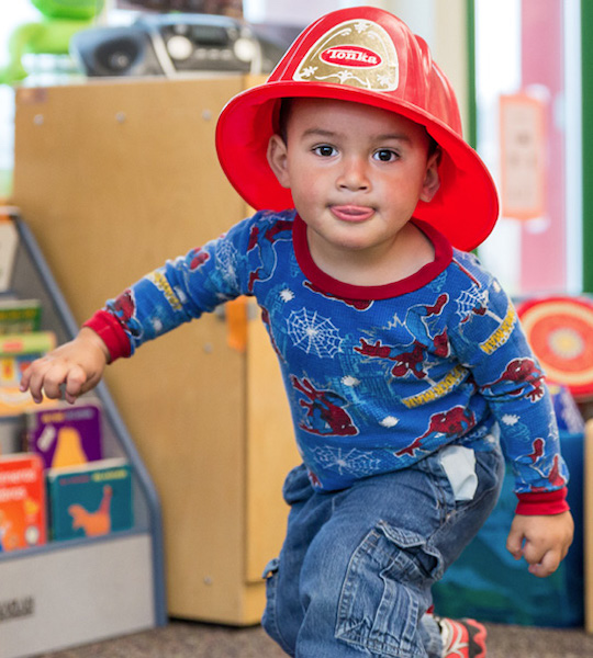 Niño pequeño con casco de bombero