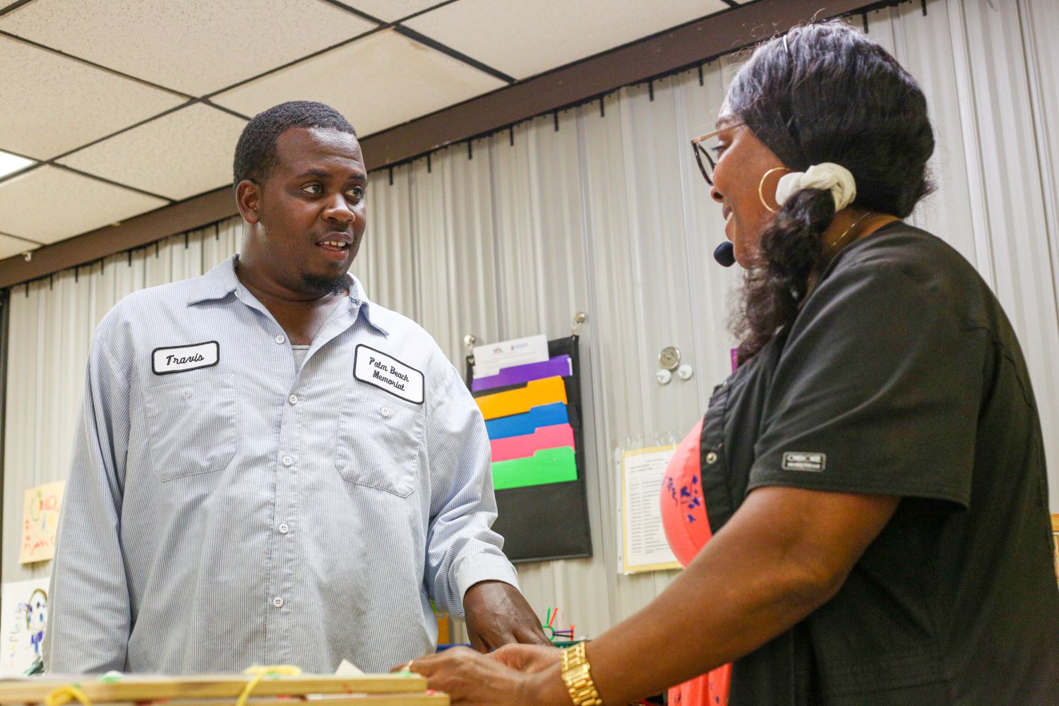 Dos adultos sonrientes hablando en el centro de Head Start.