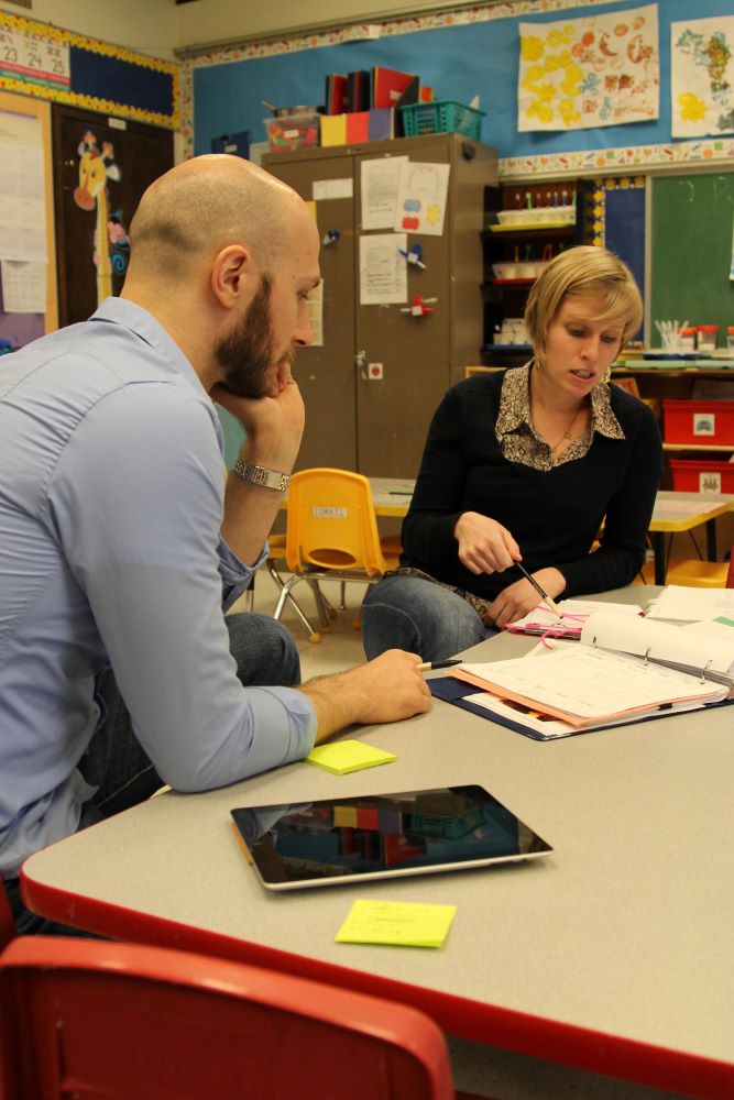 Two teachers going over their notes and planning.