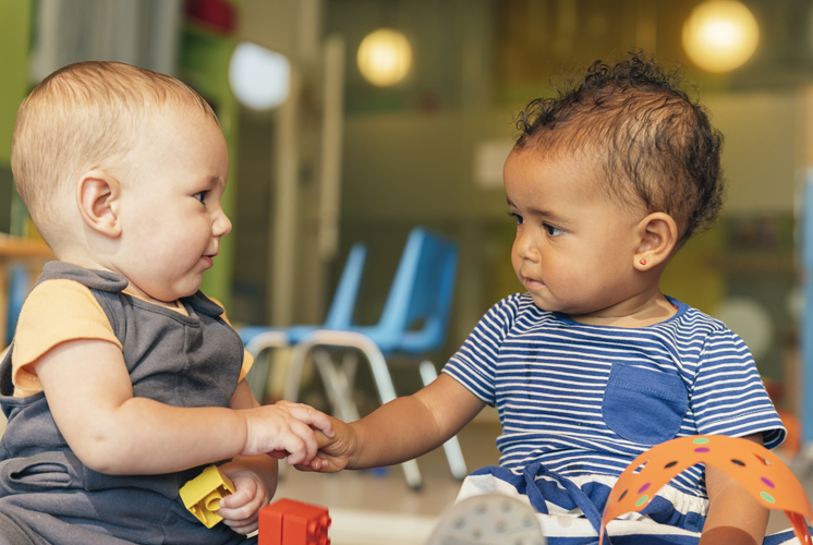 Two toddlers holding hands