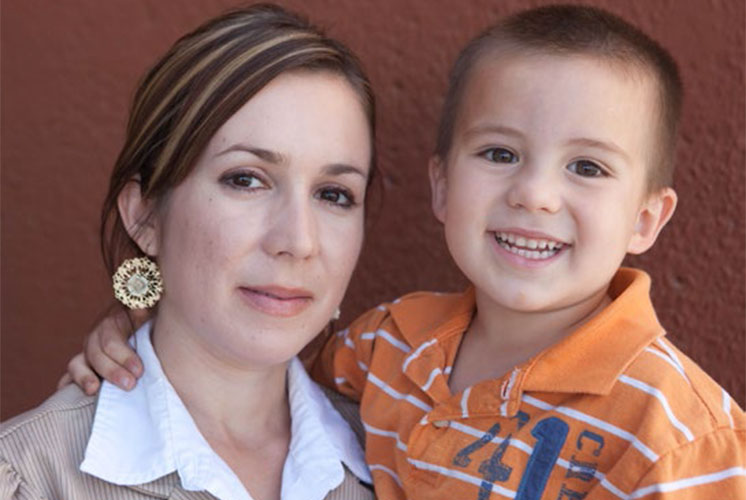 A woman and a boy together smiling into the camera