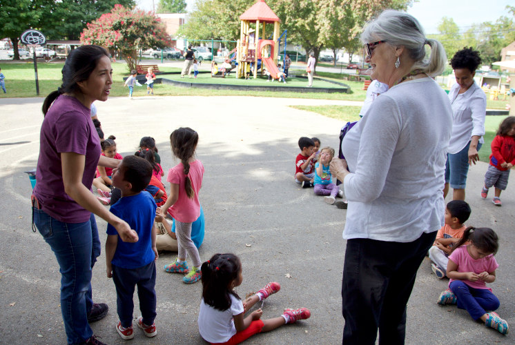 Woman holding a child talking to parents