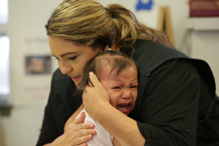 Woman holding crying child against chest