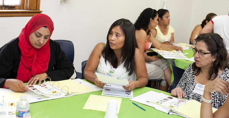 Mujeres sentadas alrededor de una mesa hablando y analizando algo