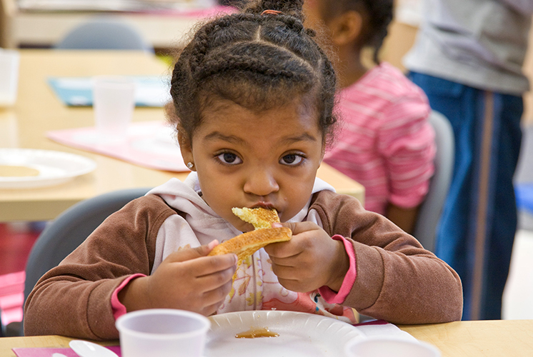 A young girl eating at the table